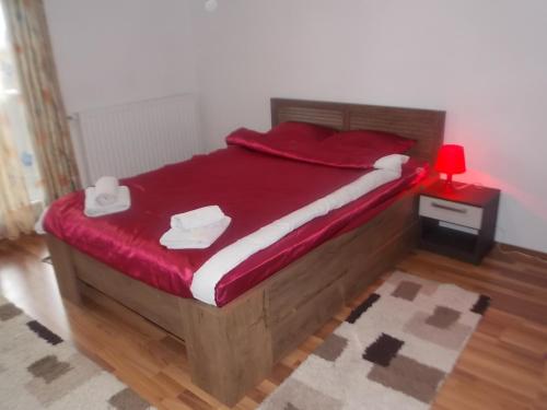 een slaapkamer met een groot bed en een rode deken bij Kuća za odmor V&E in Bihać