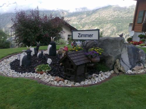 a model of a garden in a yard with a sign at Staldenried Ferienwohnung in Staldenried