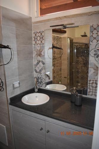a bathroom with two sinks and a large mirror at Sinuessa Studio in Mondragone