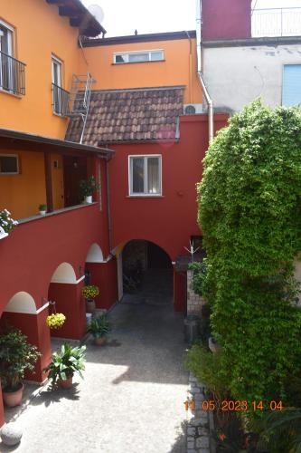 a red and orange building with a courtyard at Sinuessa Studio in Mondragone