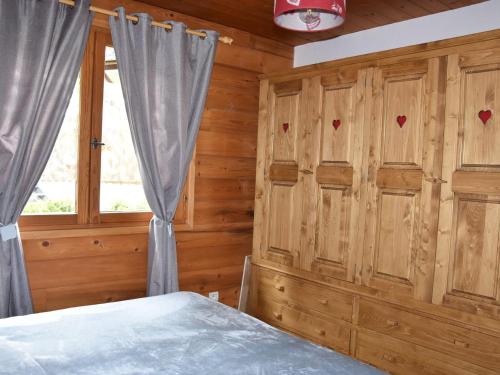 - une chambre avec des murs en bois et un lit avec une fenêtre dans l'établissement Charmant 2 pièces ensoleillé avec balcon, près des pistes et centre, parking inclus - FR-1-464-199, à Pralognan-la-Vanoise