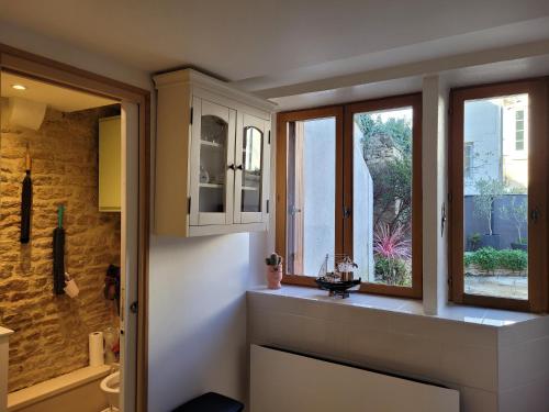 a bathroom with a sink and a window at Maison de pêcheur charmante et atypique en pierre, 1 min de marche de la mer in Saint-Aubin-sur-Mer