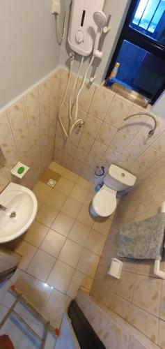 a bathroom with a toilet and a sink at Cozy Nest Oasis - Serviced Apartment in Kigali
