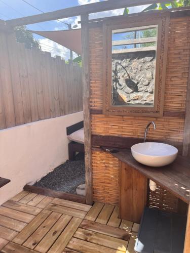 een badkamer met een wastafel en een raam bij LES VAVANGUES - L'HERMITAGE LES BAINS in La Saline les Bains