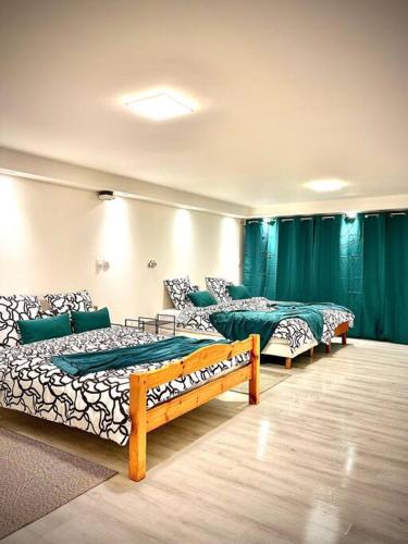 - 3 lits dans une chambre dotée de rideaux verts dans l'établissement Le Luxembourg, à Villeurbanne