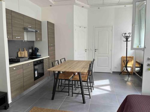 - une cuisine avec une table et des chaises en bois dans la chambre dans l'établissement Le Luxembourg, à Villeurbanne