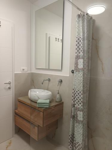 ein Bad mit einem Waschbecken und einem Duschvorhang in der Unterkunft Sun Side - Čiovo in Trogir