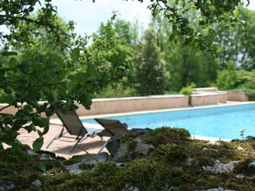- une piscine avec une chaise à côté dans l'établissement Gîte de charme en Périgord avec piscine, jardin, wifi et équipements complets - FR-1-616-321, à Saint-Capraise-dʼEymet