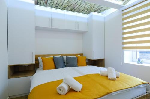 a bedroom with a large white bed with towels on it at All seasons apartments Sarajevo with free parking in Sarajevo