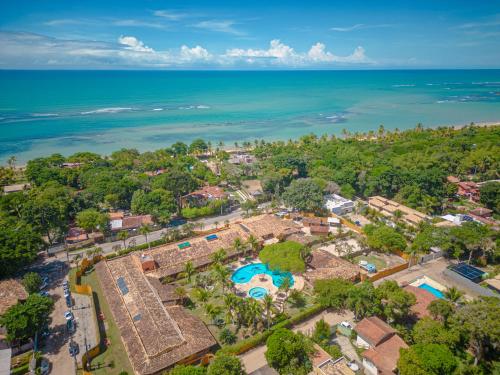 an aerial view of a resort with a pool and the ocean at Estação Santa Fé Hotel e Pousada in Arraial d'Ajuda