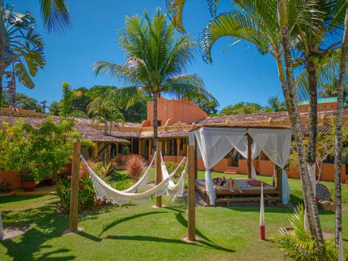 a resort with hammocks in the yard at Estação Santa Fé Hotel e Pousada in Arraial d'Ajuda