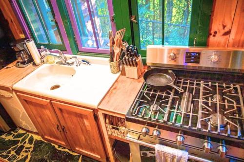 La cocina está equipada con fogones, fregadero y encimera. en Romantic Gem, 2 Acres, Hot Tub, Free Pet, King Bed, en Pigeon Forge