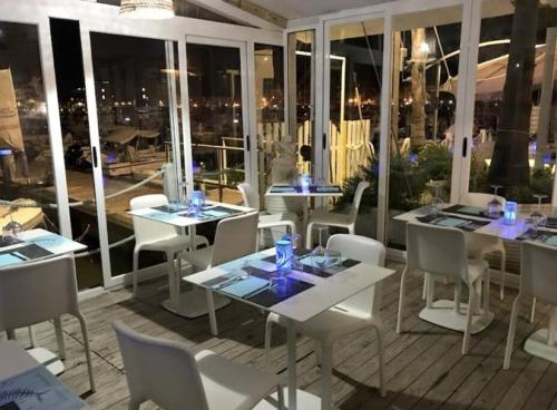 a restaurant with tables and chairs and a view of the city at Virginia Bed and Boat in Siracusa