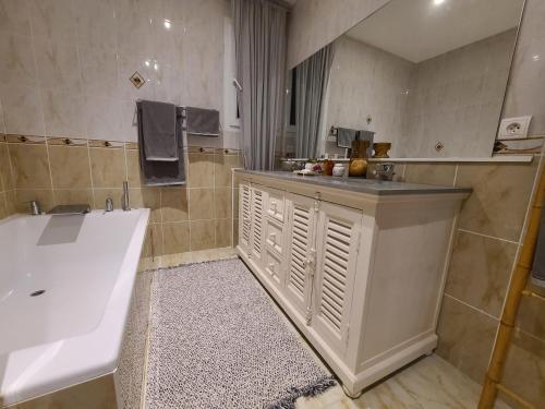 a bathroom with a tub and a sink and a bath tub at Villa Provençal in La Roque-dʼAnthéron
