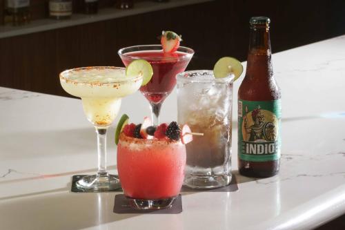 three cocktails on a table with a bottle of beer at Courtyard Monterrey Airport in Monterrey