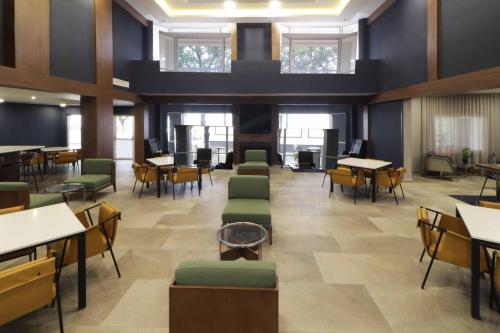 Cette grande chambre comprend des tables, des chaises, des tables et des fenêtres. dans l'établissement Courtyard Monterrey Airport, à Monterrey