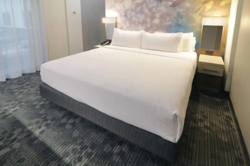 a large white bed in a hotel room at Courtyard Monterrey Airport in Monterrey