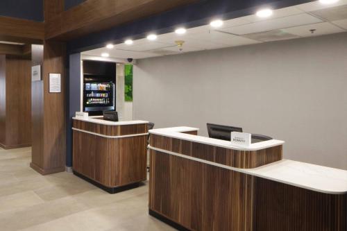 a lobby with two reception desks and a drink at Courtyard Monterrey Airport in Monterrey