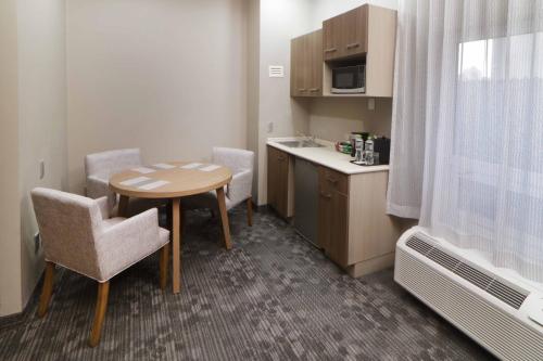 a small room with a table and chairs and a kitchen at Courtyard Monterrey Airport in Monterrey