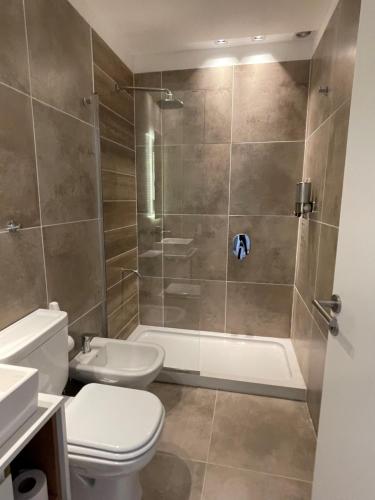 La salle de bains est pourvue d'une douche, de toilettes et d'un lavabo. dans l'établissement Departamento Rosas, à Ushuaia