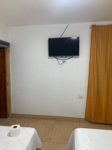 Pokój z 2 łóżkami i telewizorem na ścianie w obiekcie BOCARENA w mieście Bocapán