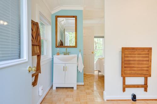 ein Bad mit einem Waschbecken und einem Spiegel in der Unterkunft Beachy Palms Cottage on Lake Huron with Hot Tub! in Palms