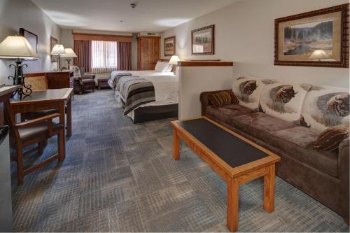 a hotel room with a couch and a bed at Creekside Lodge at Custer State Park Resort in Custer