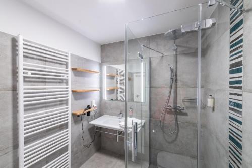a bathroom with a glass shower and a sink at Pension Typisch Naumburg in Naumburg