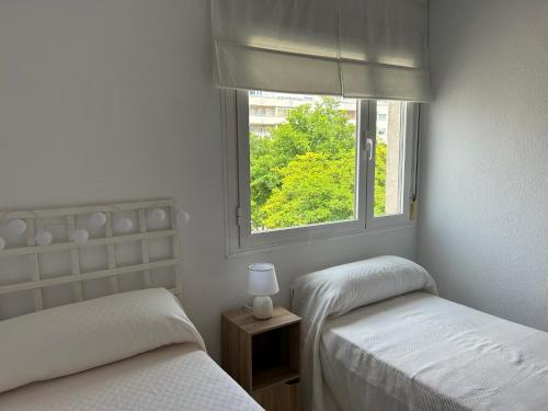 two twin beds in a room with a window at Apartamento en San Fernando centro in San Fernando