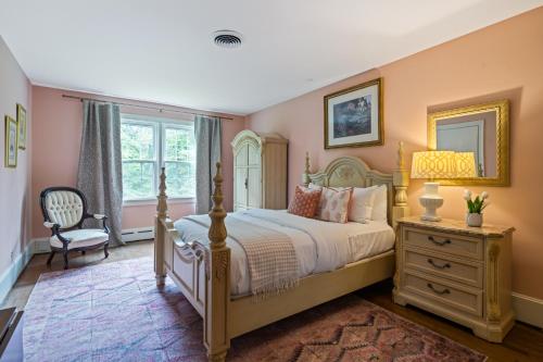 a bedroom with a bed and a chair and a window at Luxury Farmhouse in the Heart of Historic Downtown in Cartersville