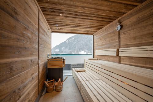 a sauna with wooden walls and a view of the water at Suites by Mein Almhof in Nauders