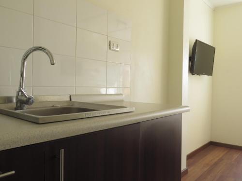 uma cozinha com um lavatório e uma bancada em Riomar Apart Hotel em Concón