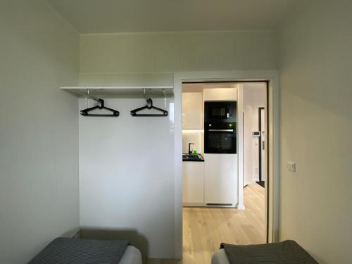 um quarto branco com uma cozinha e uma porta para um corredor em Apartament MORENA em Gdansk