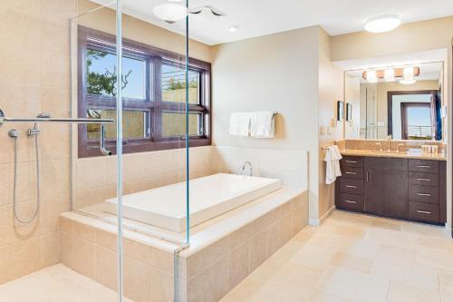 baño grande con bañera y lavamanos en Carmel Highlands Home en Carmel