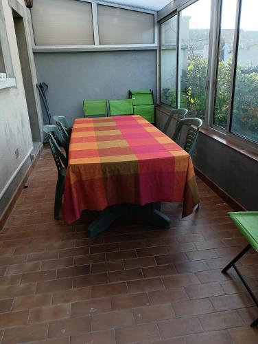 a colorful table and chairs in a room with windows at Maison in La Flèche