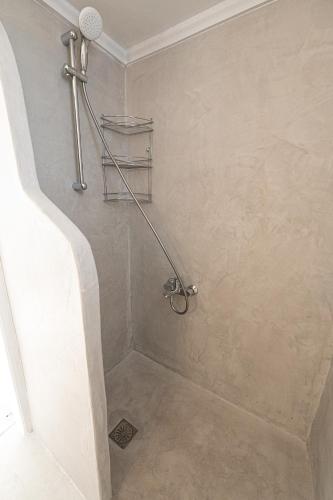 a bathroom with a shower with a towel rack at The White Rose Apartment in Poros