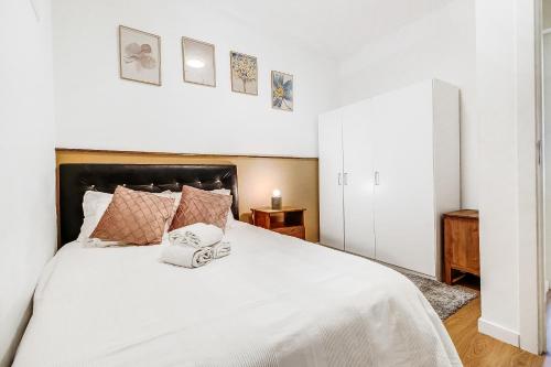 1 dormitorio con 1 cama blanca y 2 toallas en Lisboa Charming Apartment III en Lisboa