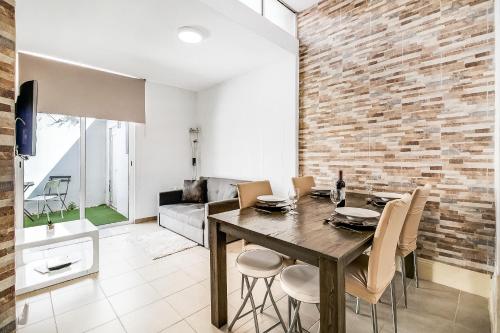 a dining room with a table and chairs and a brick wall at Lisboa Charming Apartment III in Lisbon