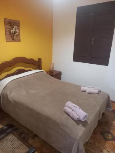 um quarto com uma cama com duas toalhas em Mini Casarão em São Bento do Sapucaí