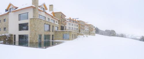 a group of buildings in the snow at Loi Suites Chapelco Hotel in San Martín de los Andes