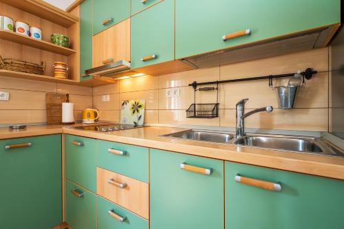 eine Küche mit blauen Schränken und einem Waschbecken in der Unterkunft Sunny Apartments in Stobreč