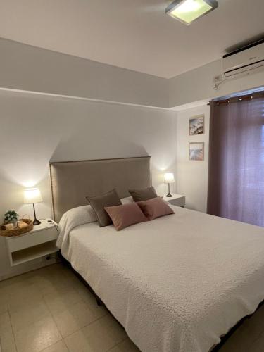1 dormitorio con 1 cama blanca grande y 2 lámparas en Bitcoins House Costanera en Corrientes
