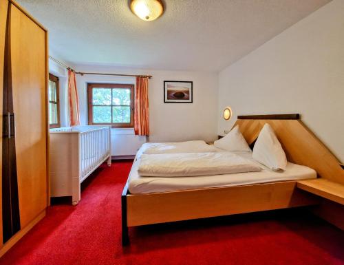 a bedroom with a bed with a red carpet at Ferienhaus Alpenschlössl in Lermoos