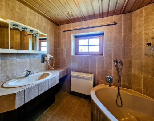 a bathroom with a sink and a bath tub at Ferienhaus Alpenschlössl in Lermoos