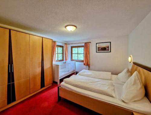 um quarto com uma cama e um berço em Ferienhaus Alpenschlössl em Lermoos