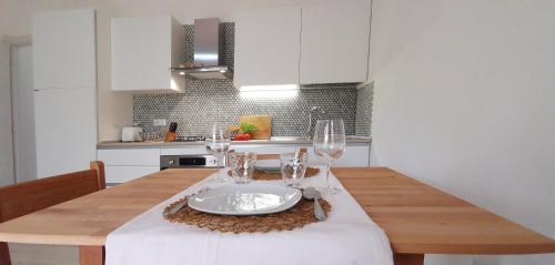 a kitchen with a table with a plate and wine glasses at Patio House in Siniscola