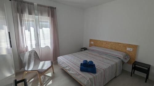 Un dormitorio con una cama con un par de zapatos azules. en Ona Beach daimuz, en Daimuz