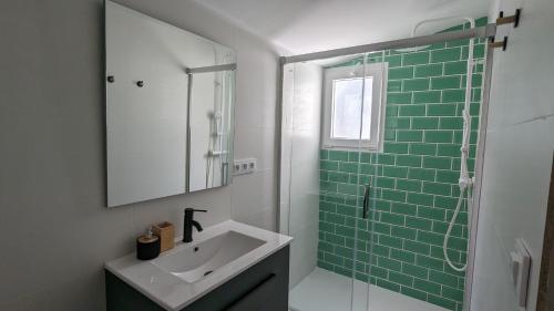 La salle de bains est pourvue d'un lavabo et d'une douche en verre. dans l'établissement Ona Beach daimuz, à Daimús