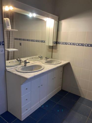 La salle de bains est pourvue de 2 lavabos et d'un grand miroir. dans l'établissement Charmante villa dans un lotissement très calme, à Béziers