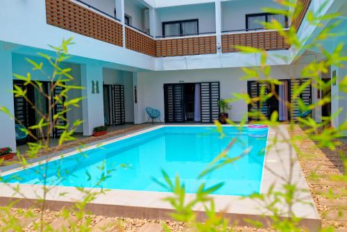 a swimming pool in front of a house at Ofim Holidays in Ambohidratrimo